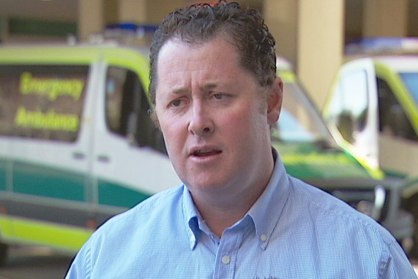 Minister Jack Snelling with an ambulance behind him