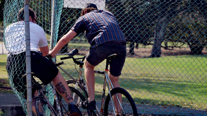 A bike polo player crashes into the fence