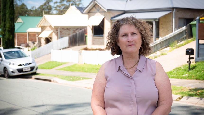 A woman stands in the middle of her suburb in Springfield Lakes. 