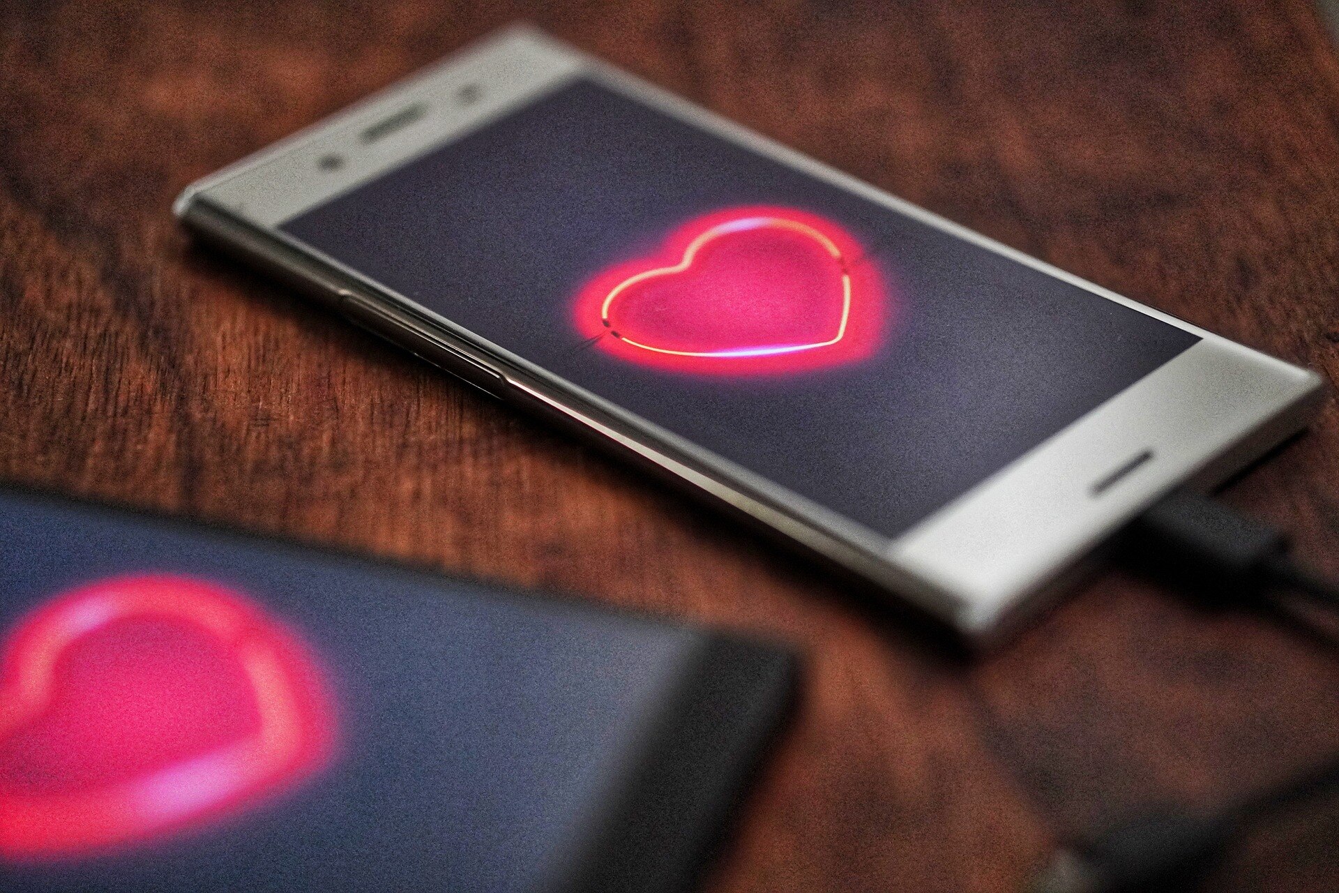 Two mobile phones with hearts on the screens