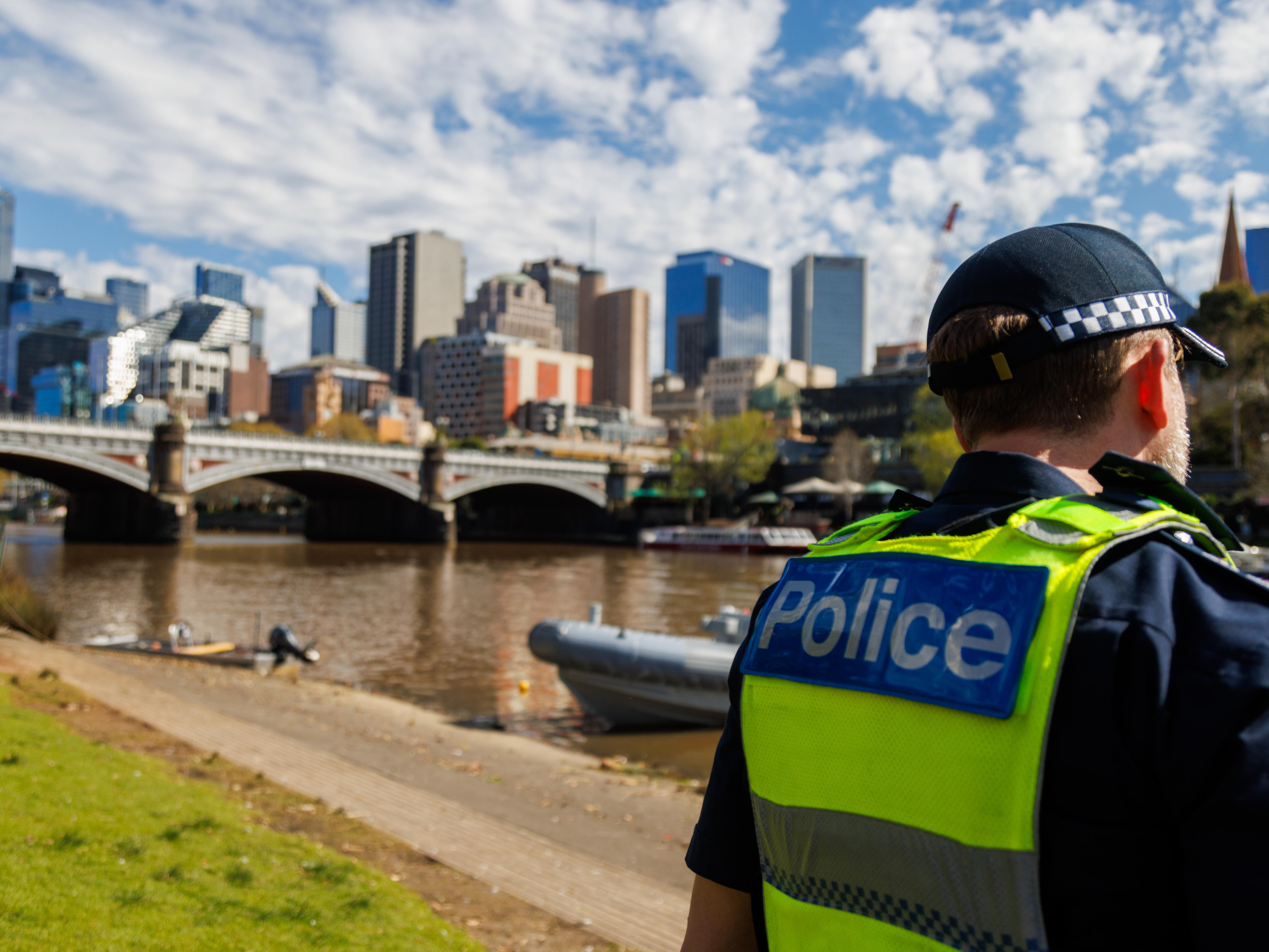 A Victoria Police officer on the banks of the Yarra River