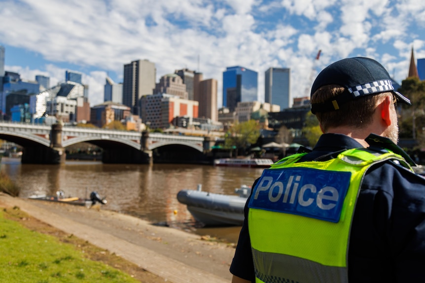 A Victoria Police officer on the banks of the Yarra River