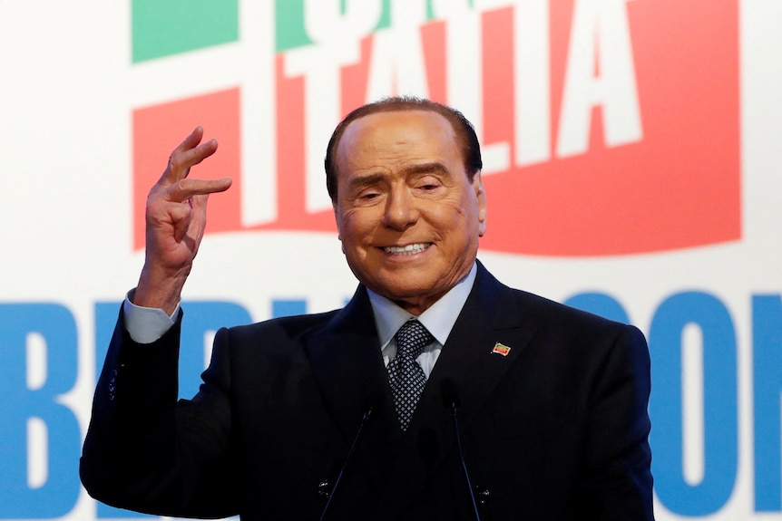 Silvio Berlusconi waving a raised hand