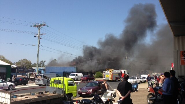 People watch a fire that broke out at a mechanical workshop at Slacks Creek.