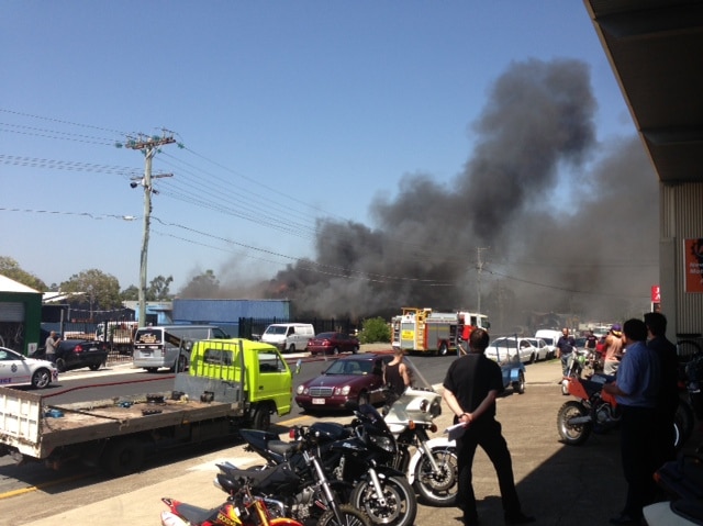 People watch a fire that broke out at a mechanical workshop at Slacks Creek.