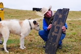 A farmer holding space junk next to his dog