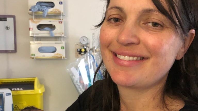 a mum holds her baby in a hospital room