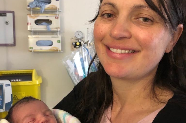 a mum holds her baby in a hospital room
