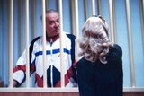 Sergei Skripal is seen on a monitor talking to his lawyer from behind bars.