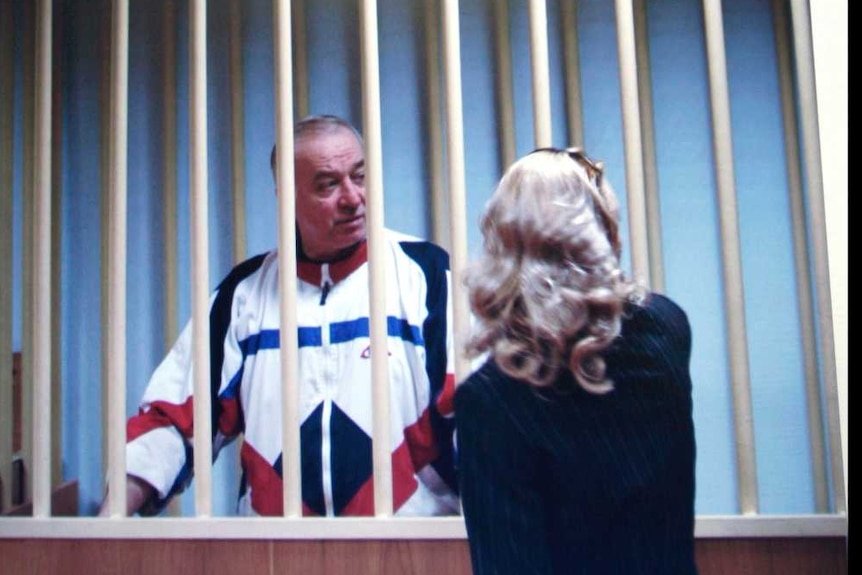 Sergei Skripal is seen on a monitor talking to his lawyer from behind bars.