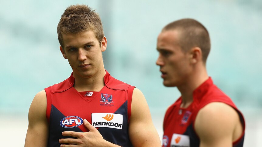 Jack Trengove looks at Demons team-mate Tom Scully out of focus in the foreground