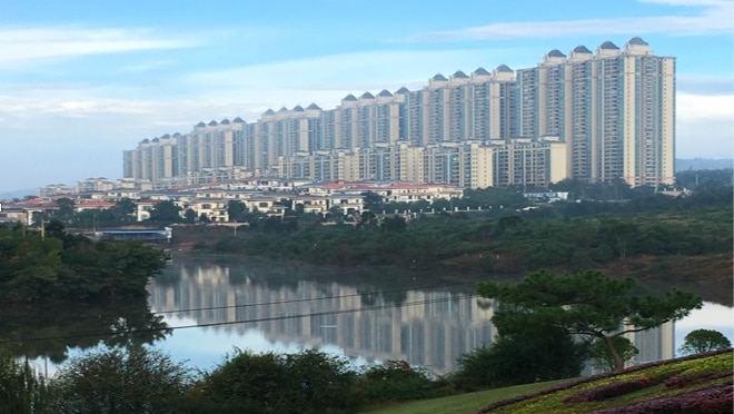 A row of high-rise apartment towers next to a body of water.
