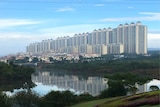 A row of high-rise apartment towers next to a body of water.