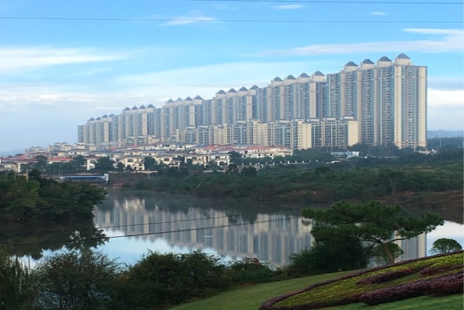 A row of high-rise apartment towers next to a body of water.