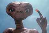An alien holds up a lit finger