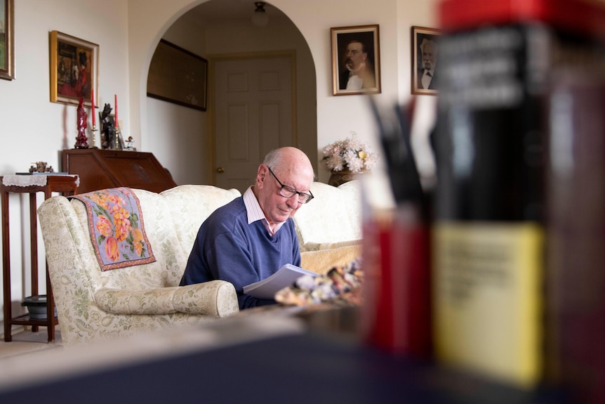 A man sits on a sofa in his living room