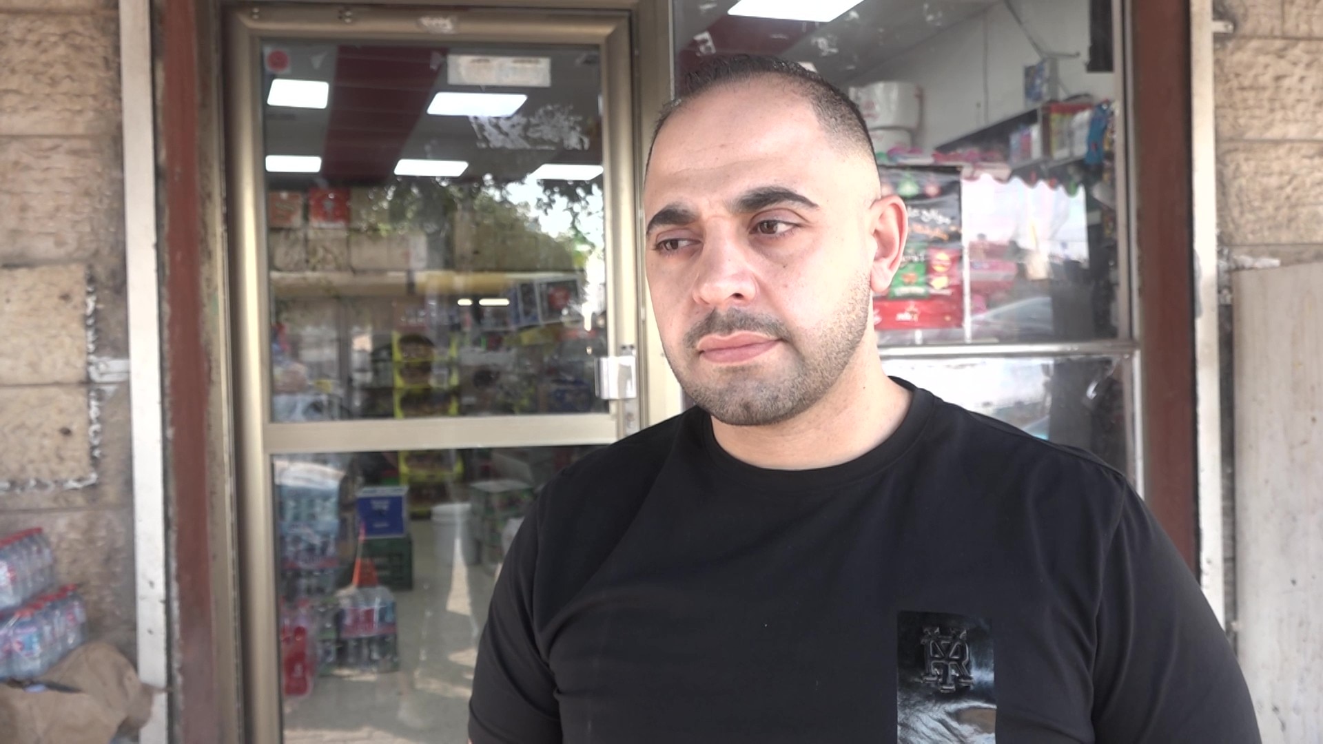 A man standing outside a convenience store