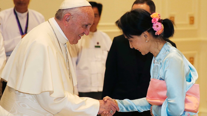 Pope Francis shakes hands with Aung San Suu Kyi.