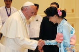 Pope Francis shakes hands with Aung San Suu Kyi.