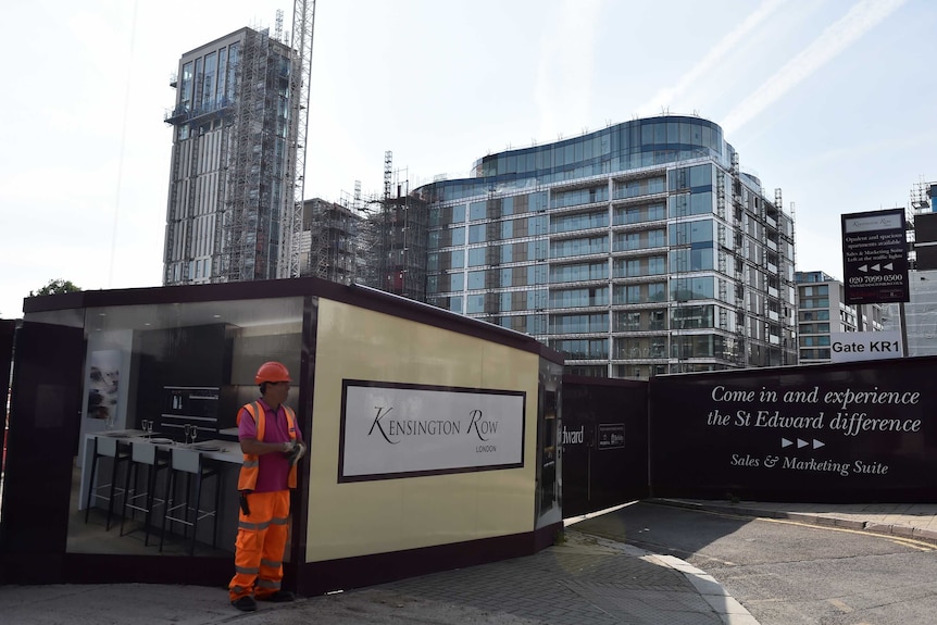 A workers stands outside the new housing development.