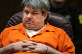 Jason Dalton sits in court wearing a orange jumpsuit and handcuffs.