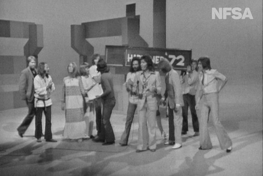 A group of people on the set of a TV show in the 70s.
