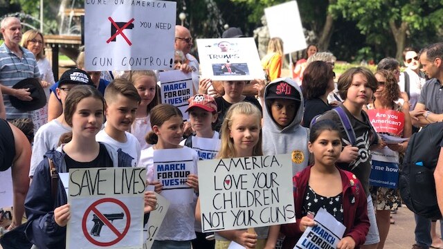 A group of children hold placards