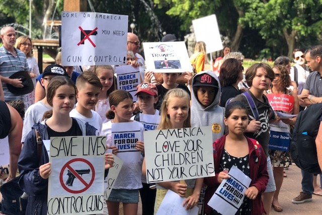 A group of children hold placards