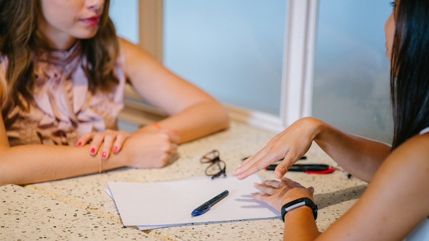 Two women chatting for talking about changing your name to improve your chances when looking for a job.