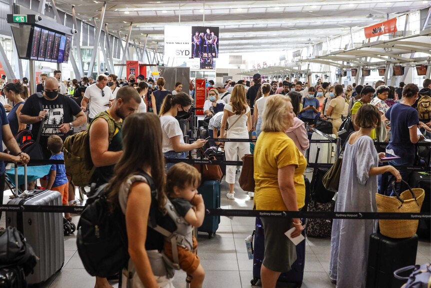 long queues at Sydney Airport with people waiting for baggage