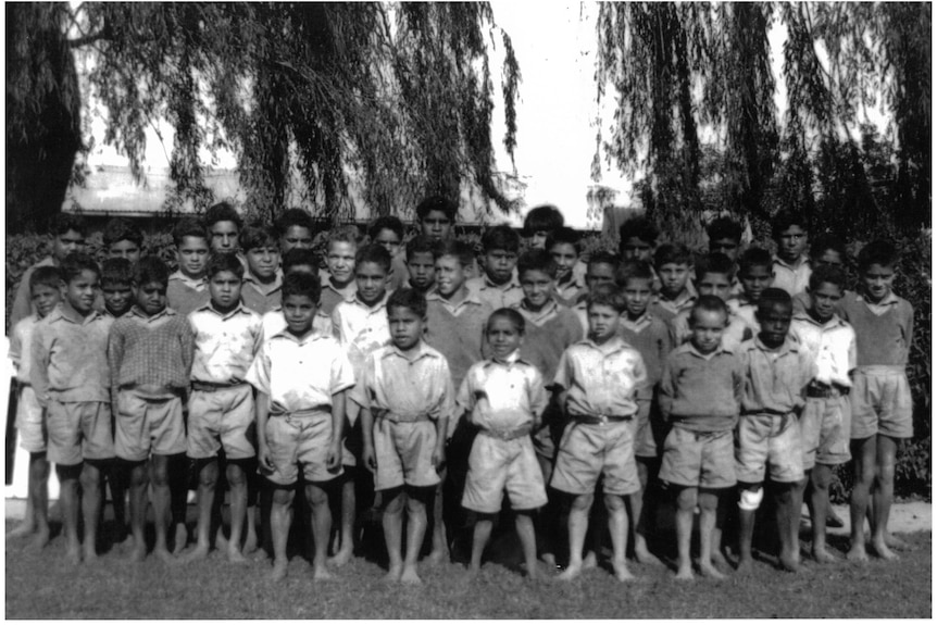 young boys standing in a line outdoors