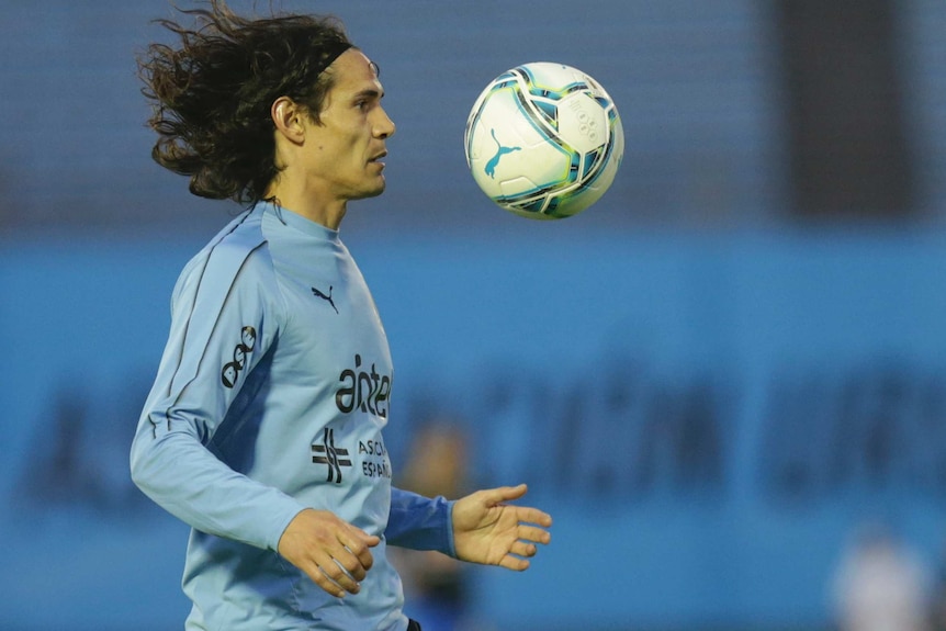 A player in a blue jersey chests a ball during a warm-up.