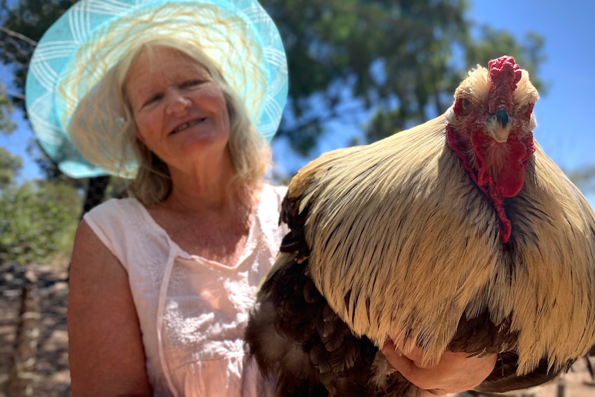 a woman is wearing a hat and holding 