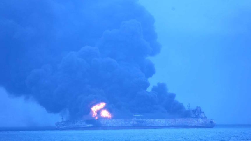 Smoke and flames are seen pouring from a tanker in the ocean.