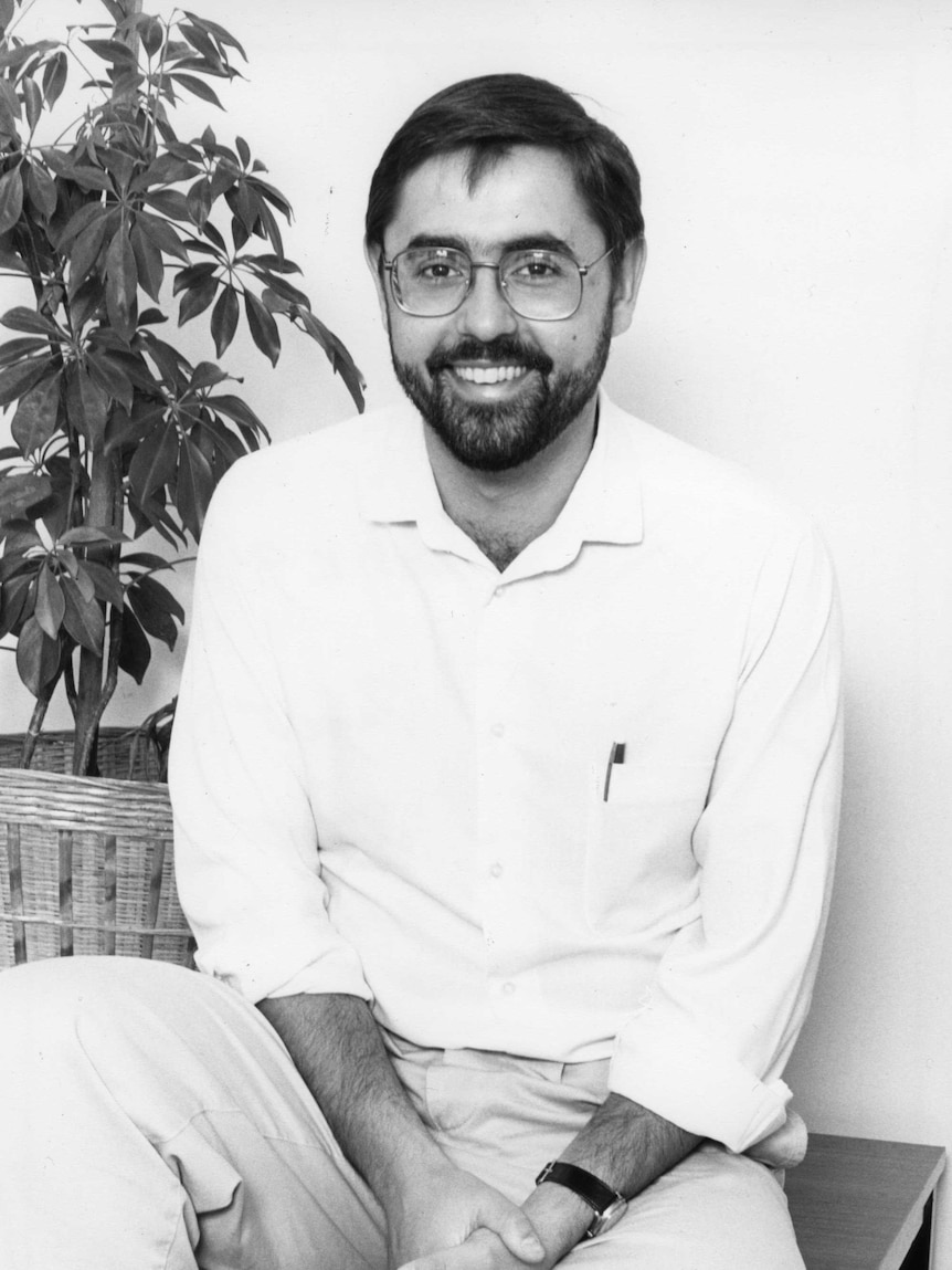 Black and white photo of a young Swan with a beard and wearing glasses.