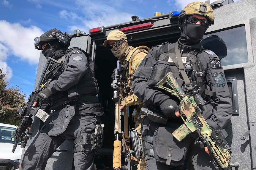 Special Emergency Response Team officers emerging from the back of a troop carrier