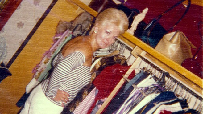 A vintage photo of a woman standing in a wardrobe