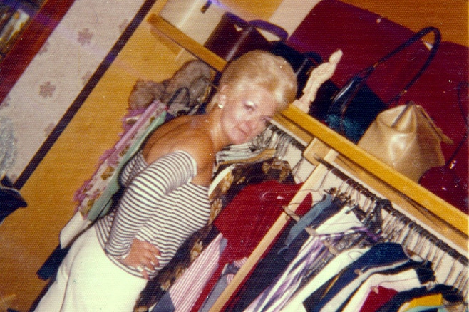 A vintage photo of a woman standing in a wardrobe