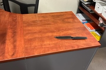 brown desk with knife with black handle