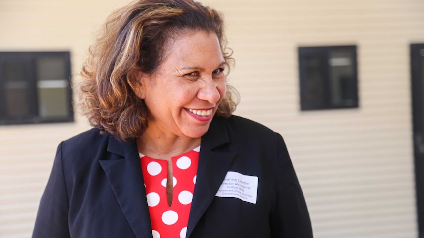 A woman smiles at camera.