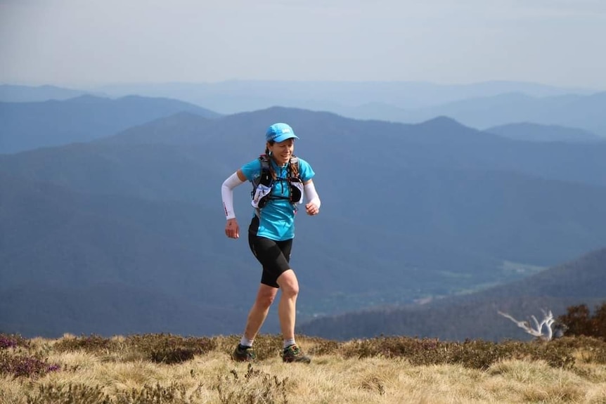 A woman running on a mountain top.