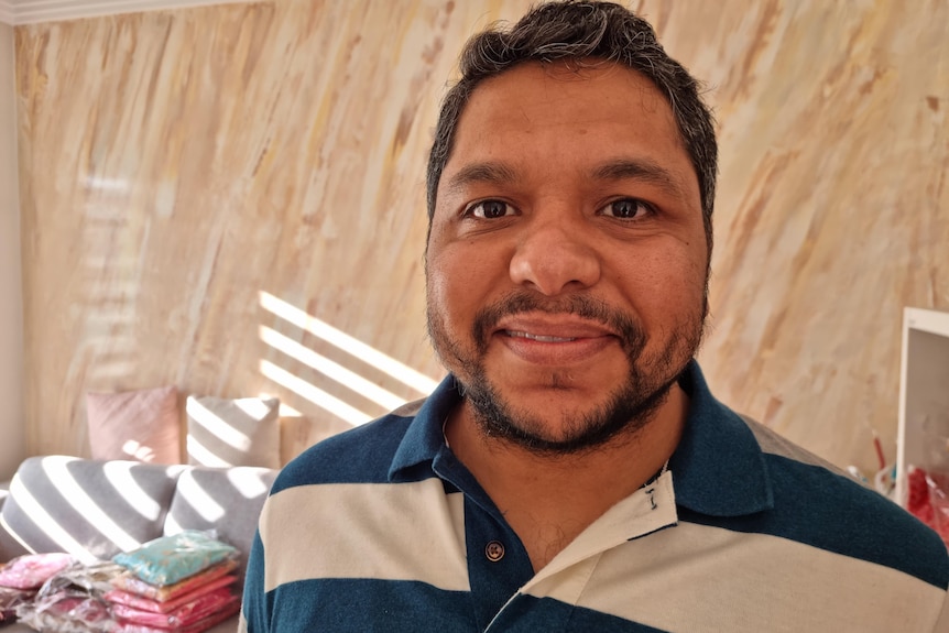 A man with dark hair smiles at the camera.