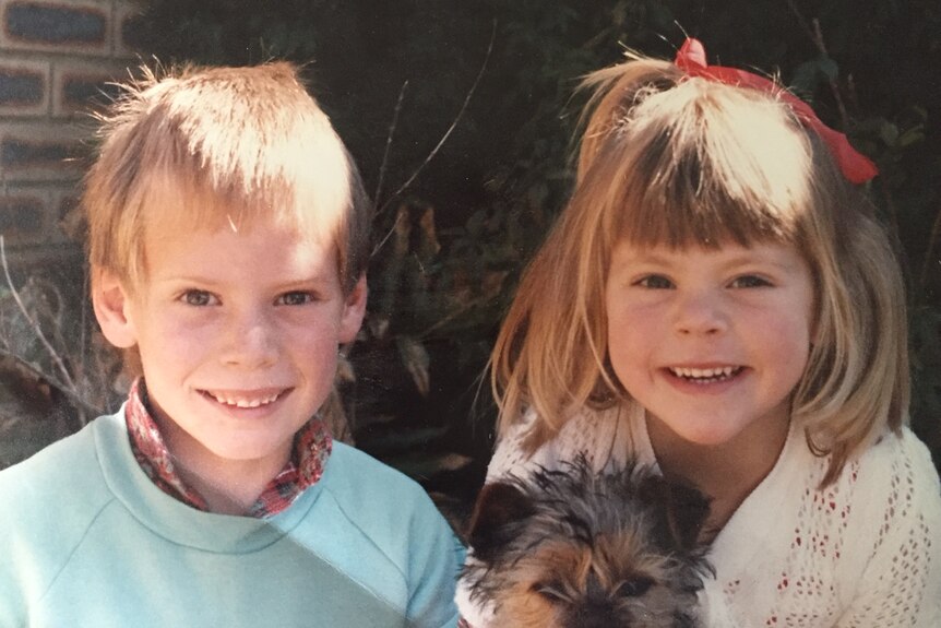Ben Curtis as a young boy poses for a photo with his young sister and a small dog.
