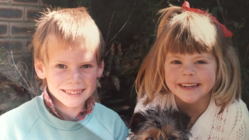 Ben Curtis as a young boy poses for a photo with his young sister and a small dog.