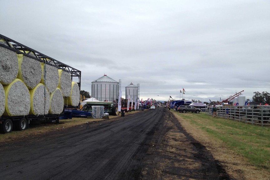 A roadway with various farm equipment along its edge.