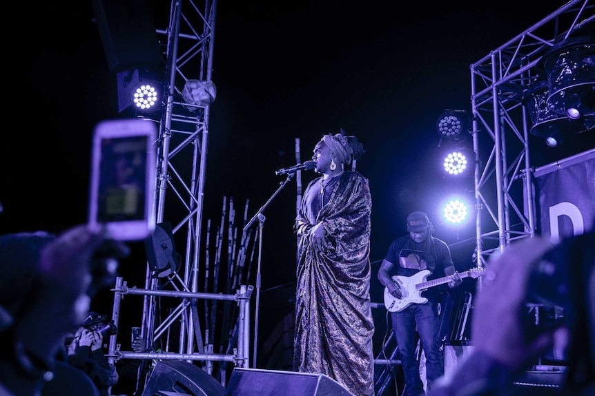 Colour photo of Zaachariaha Fielding of Electric Fields singing on stage at night time at Dance Rites 2018.