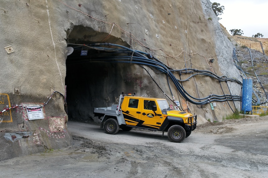 an electric vehicle exits a mine tunnel.