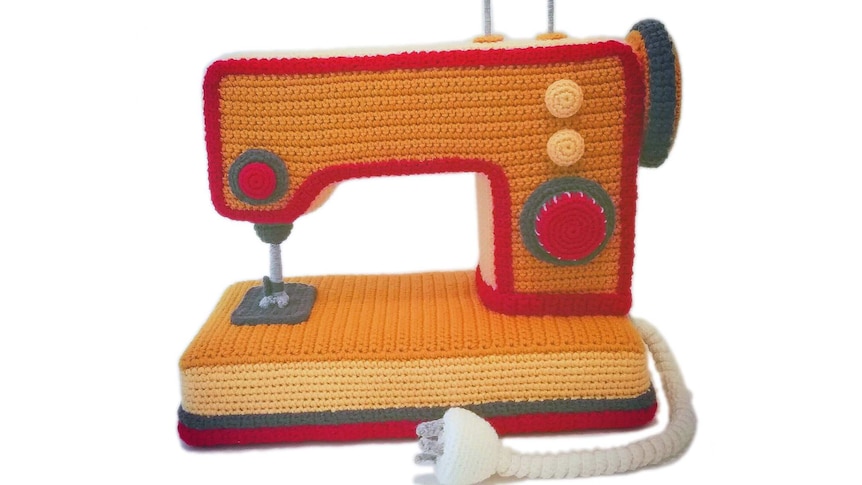 A bright orange crocheted sewing machine