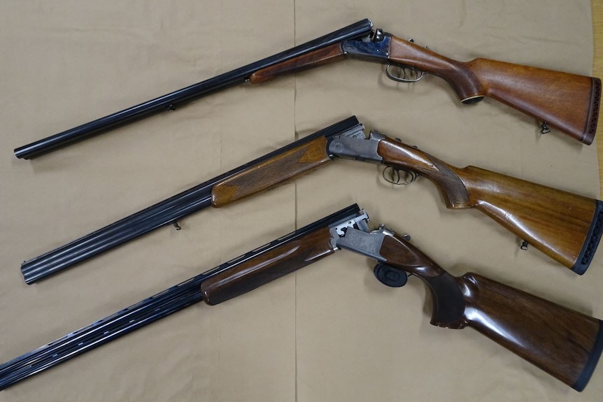 Three rifles lying next to each other on a table