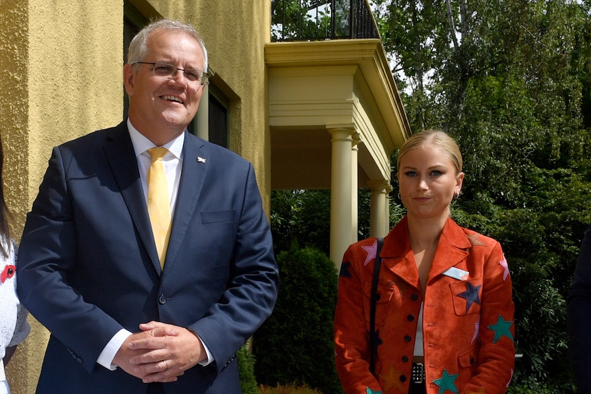 Prime Minister Scott Morrison stands next to Grace Tame outside a building.